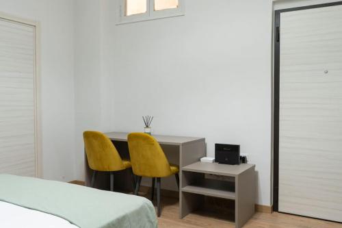 una camera da letto con una scrivania e 2 sedie gialle di Appartamento RealValle Verde a Scafati