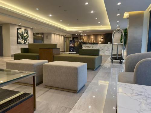 a lobby with couches and tables in a building at SMDC Green 2 Staycation, The Traditional & Modern Fusion Condo in Pasong Bayog