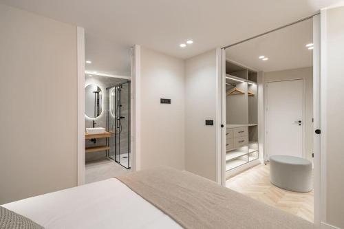 Habitación blanca con cama y espejo en Luxury flat Mayor V, en Madrid