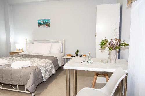 een slaapkamer met een bed en een tafel en stoelen bij Traveller's Nest Studio close to center,port,airport in Heraklion