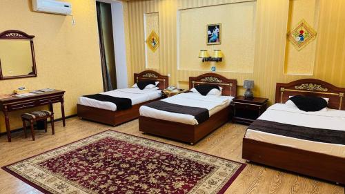 a hotel room with two beds and a rug at ORIYO DUSHANBE HOTEL in Dushanbe