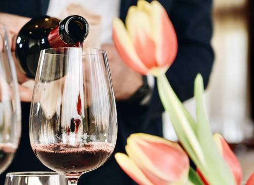 a person pouring wine into a wine glass at Hotel Le Grotte in Genga