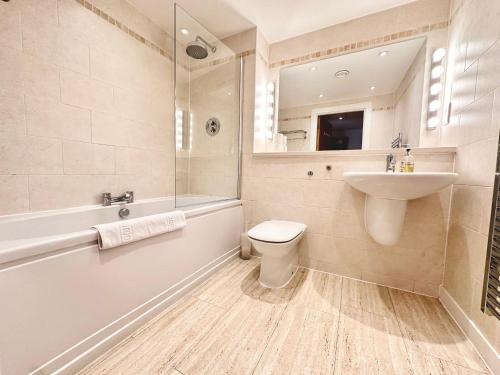 een badkamer met een wastafel, een toilet en een bad bij The Works - Two bed penthouse in Manchester