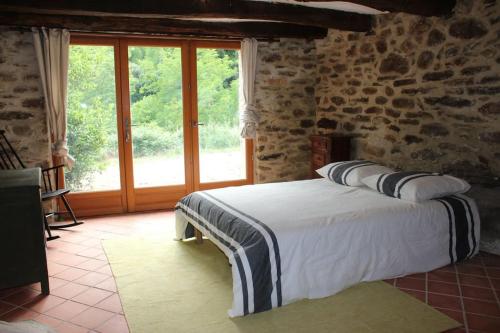 um quarto com uma cama e uma grande janela em LE JARDIN DEL SUD em Saint-Vincent