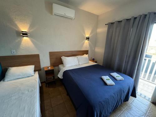 a hotel room with two beds and a window at Hotel Recanto do Sossego in Uberlândia