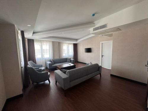 STAR SUIT HOTEL في طرابزون: غرفة معيشة مع كنب وكراسي في مبنى