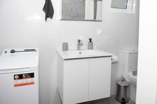 a white bathroom with a sink and a toilet at Kolymvari Hills in Chania Town