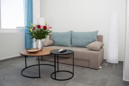 a living room with a couch and a table with flowers at Kolymvari Hills in Chania Town