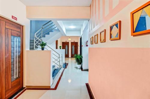 a hallway with stairs and paintings on the walls at Super OYO Home Elegant RK Fursungi in Pune