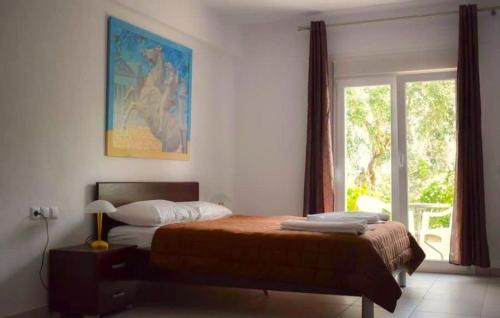 a bedroom with a bed and a large window at Thasos Seaside Serenity - Seaview & Garden Nests in Astris