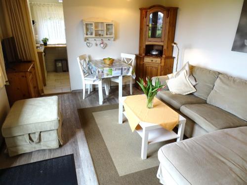 una sala de estar con un sofá y una mesa en Ferienhof Specht - Sommerhaus, en Dahme