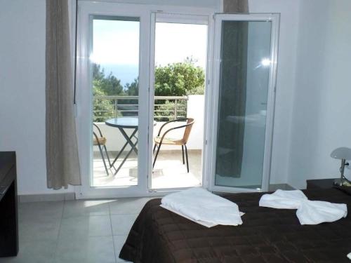 sypialnia z łóżkiem oraz balkon ze stołem w obiekcie Thasos Seaside Serenity - Seaview & Garden Nests w mieście Astris
