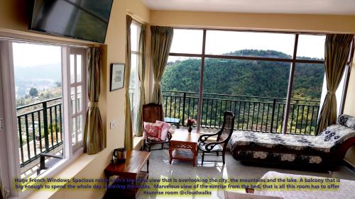 a living room with a large window with a view at Cloudwalks Homestay in Kodaikānāl