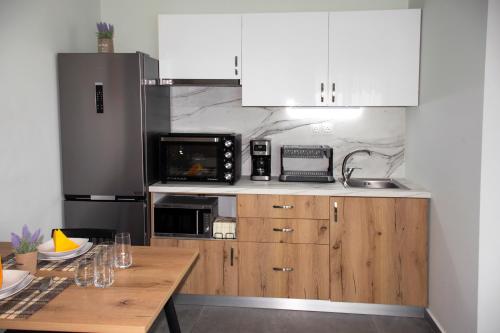 a kitchen with white cabinets and a wooden table at Kolymvari Hills in Chania Town