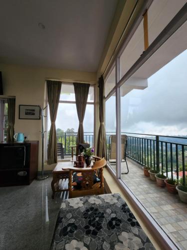 a living room with a balcony with a view of the ocean at Cloudwalks Homestay in Kodaikānāl