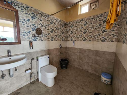 a bathroom with a toilet and a sink at Cloudwalks Homestay in Kodaikānāl