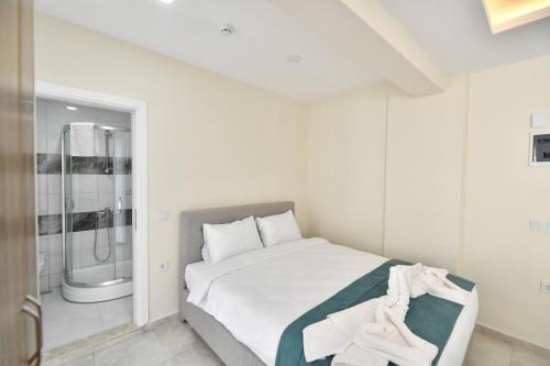 una camera bianca con letto e doccia di Lamira Apart Holiday&Guest House a Fethiye