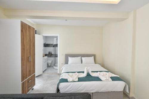ein Schlafzimmer mit einem Bett mit zwei Handtüchern darauf in der Unterkunft Lamira Apart Holiday&Guest House in Fethiye