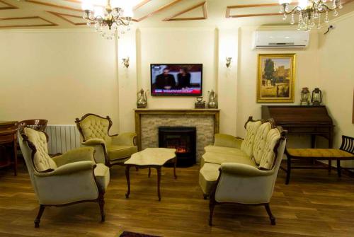 Oba Hotel في إسطنبول: غرفة معيشة مع كراسي ومدفأة وتلفزيون