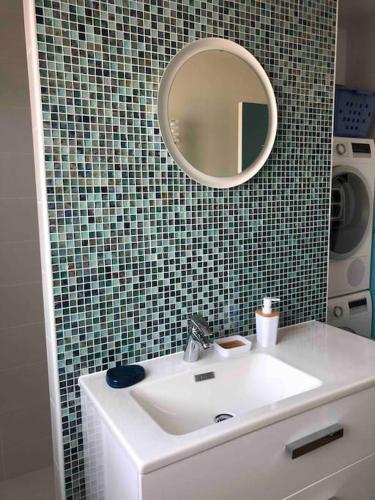 une salle de bain avec un lavabo et un miroir dans l'établissement Une vue panoramique sur la baie de Concarneau, à Concarneau