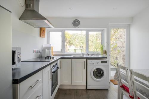 uma cozinha com um lavatório e uma máquina de lavar roupa em Parliament Street Town House em Ennistymon