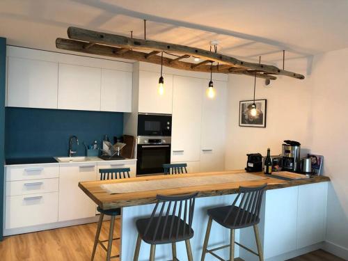 une cuisine avec un comptoir en bois et des chaises dans l'établissement Une vue panoramique sur la baie de Concarneau, à Concarneau