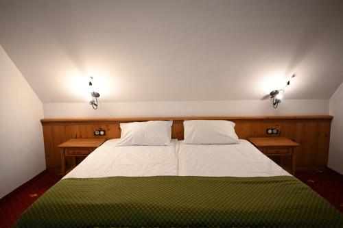 a bedroom with a bed with two lights on it at Mercure Sighisoara Binderbubi Hotel & Spa in Sighişoara
