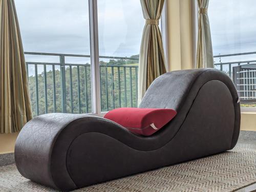 a black and red bed in a room with a window at Cloudwalks Homestay in Kodaikānāl