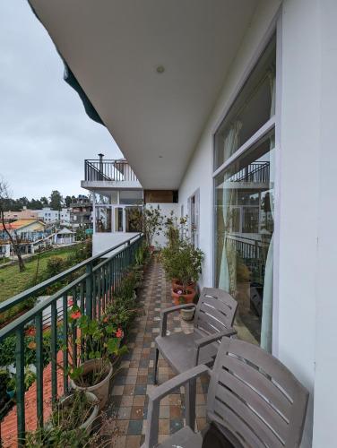 two chairs on the balcony of a house at Cloudwalks Homestay in Kodaikānāl