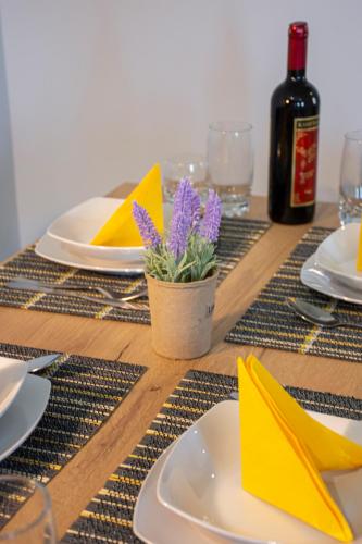 a wooden table with a table set with yellow napkins at Kolymvari Hills in Chania Town