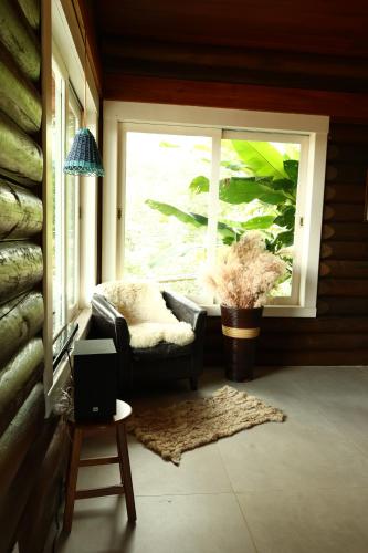 a living room with a chair and a window at Aldeia Flor de Liz - Pedra Azul in Pedra Azul