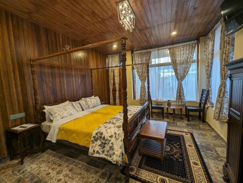 a bedroom with a canopy bed and a table and chairs at Cloudwalks Homestay in Kodaikānāl