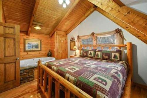 1 dormitorio con cama y bañera en A Charming Cabin, Pool, Firepit, Hot Tub-jacuzzi en Gatlinburg