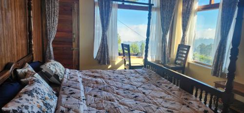 a bedroom with a bed with a large window at Cloudwalks Homestay in Kodaikānāl