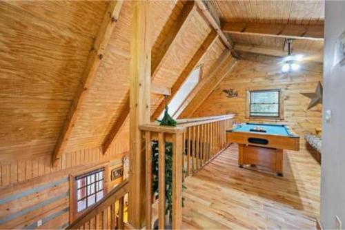 a wooden cabin with a pool table in it at A Charming Cabin, Pool, Firepit, Hot Tub-jacuzzi in Gatlinburg