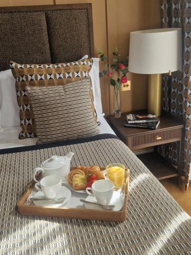ペイントンにあるレッドクリフ ホテルのベッドの上に朝食用の食材を入れたトレイ