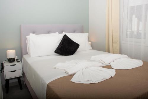 a white bed with white pillows and towels on it at Kolymvari Hills in Chania Town