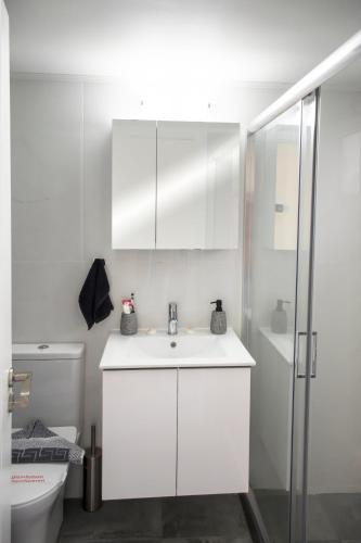 a white bathroom with a sink and a shower at Kolymvari Hills in Chania Town