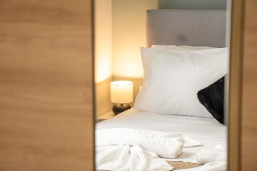 a bedroom with a bed with white sheets and a lamp at Kolymvari Hills in Chania Town