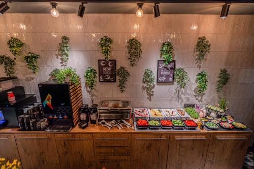 a counter with food and plants on the wall at Ibis Szczecin Centrum in Szczecin