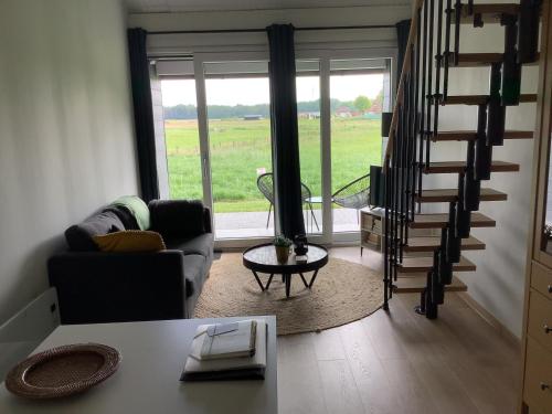 a living room with a spiral staircase and a couch at Gastenverblijf Dalem met hottub en landelijk in Hapert
