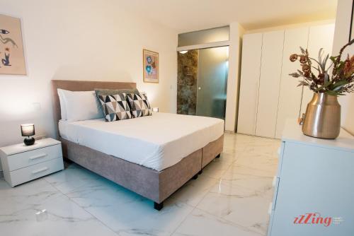 a bedroom with a bed and a vase of flowers at Mensija Valley Residences in St Julian's
