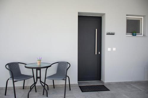 a table and chairs in a room with a black door at Kolymvari Hills in Chania Town