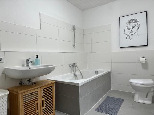 La salle de bains est pourvue d'un lavabo, d'une baignoire et de toilettes. dans l'établissement Ferienhaus "Jasmine" Hettstedt, à Hettstedt