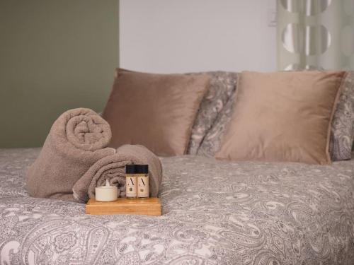 - un lit avec des serviettes, un livre et une bougie dans l'établissement Studio Cosy Fleur de Lys, à Versailles