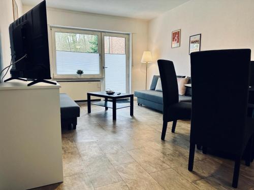 a living room with a television and a couch at FeWo Am Hang mit Balkon im Grünen in Bad Bentheim