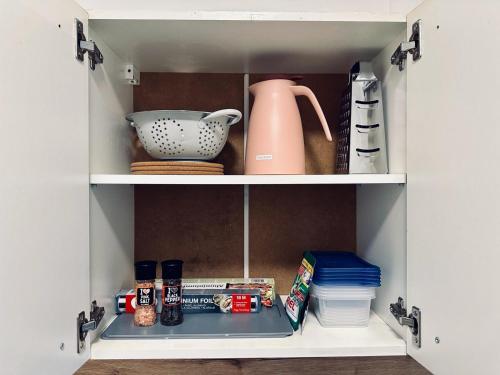 a cupboard with a tea pot and other kitchen items at FeWo Am Hang mit Balkon im Grünen in Bad Bentheim