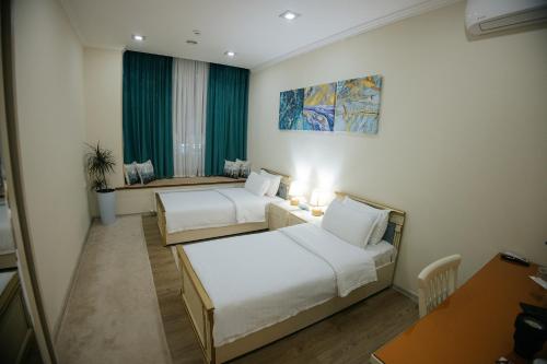um quarto de hotel com duas camas e uma mesa em Like INN Hotel em Samarkand