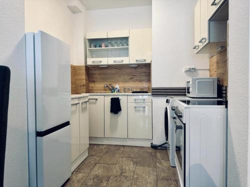 a kitchen with white appliances and a white refrigerator at FeWo Am Hang mit Balkon im Grünen in Bad Bentheim