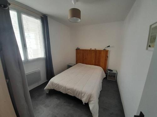 une petite chambre avec un lit et une fenêtre dans l'établissement Charmant T2 entre Plage et Commerces avec TV, Cuisine équipée, Animaux admis à Saint-Hilaire-de-Riez - FR-1-324A-27, à Saint-Hilaire-de-Riez